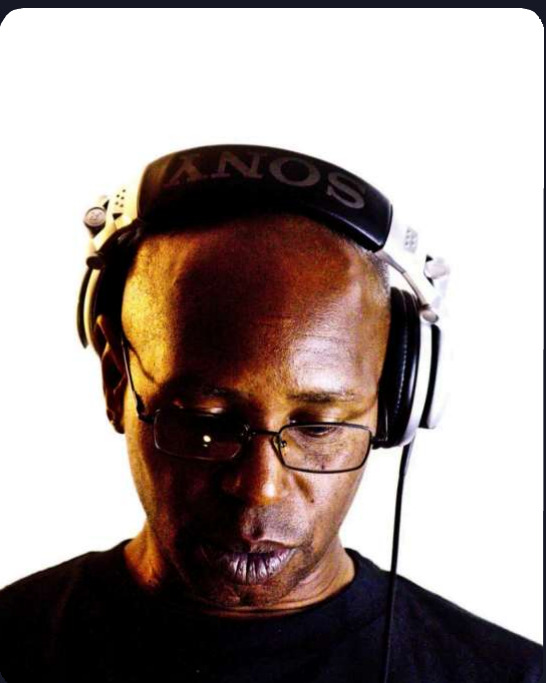 Studio portrait of John Parker wearing headphones, looking down