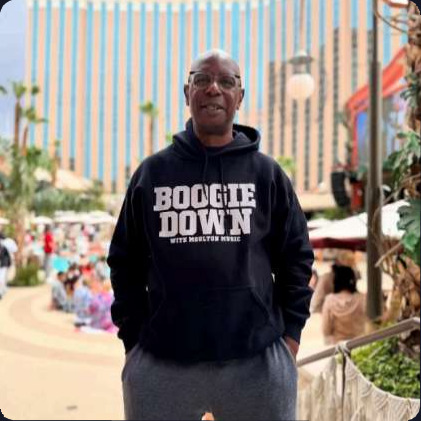 John Parker outdoors in a Boogie Down hoodie at a daytime resort party